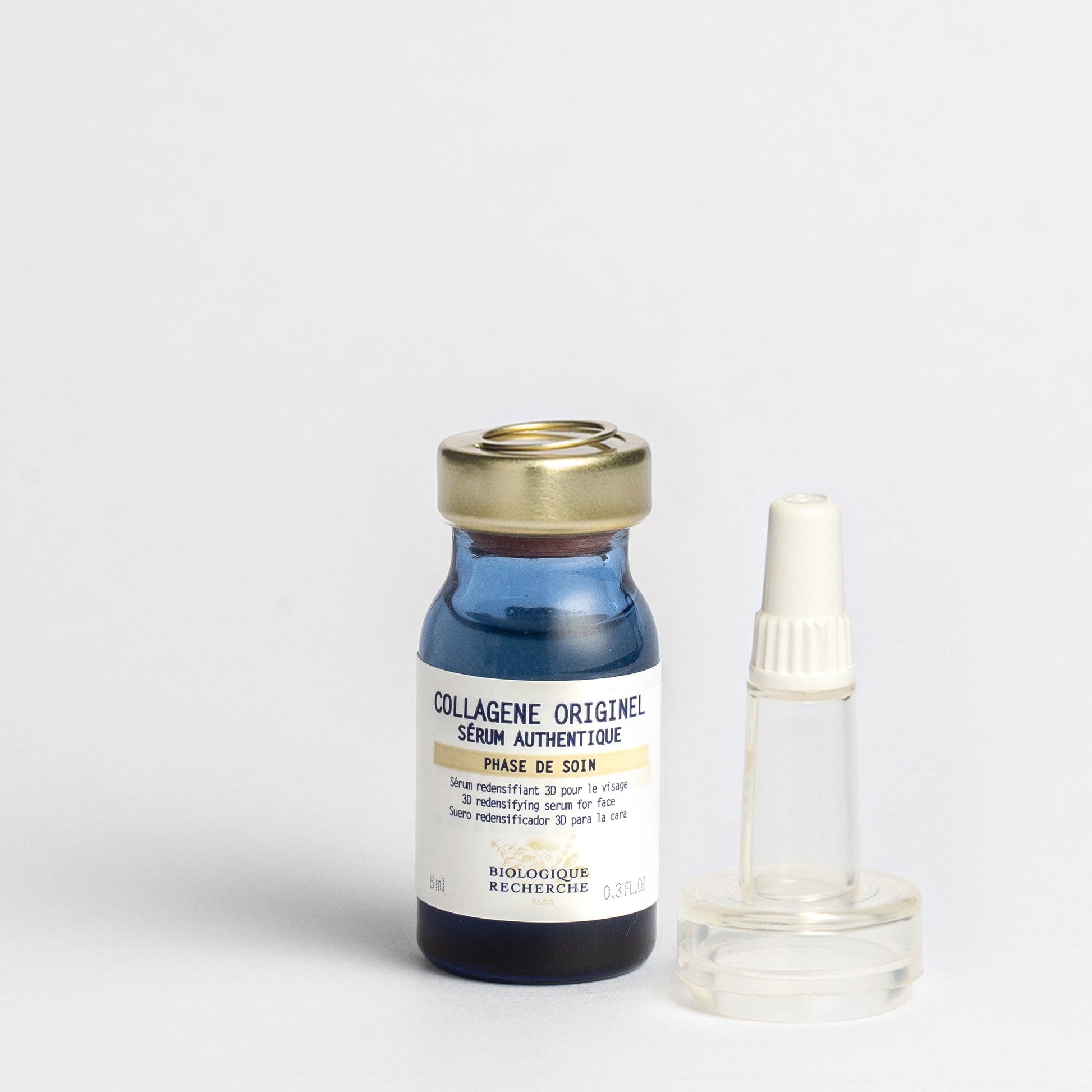 Bottle of 'Collagène Originel' serum with a gold cap and pipette on a light gray background 8ml